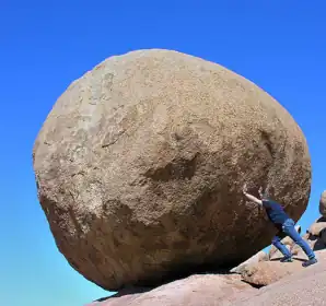 Man pushing on a rock